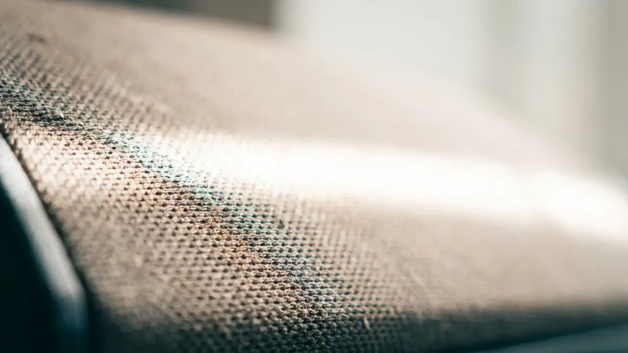 Extreme close-up of the fabric grille of a small speaker with light across the weave