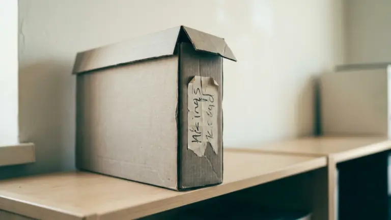 A labelled archive box file on an office shelf with a date written on the spine